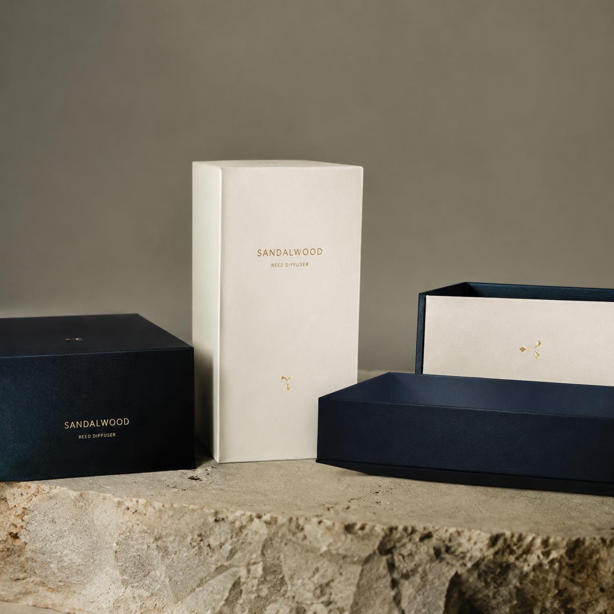 Private-label packaging boxes in navy and off-white with brass foil detail